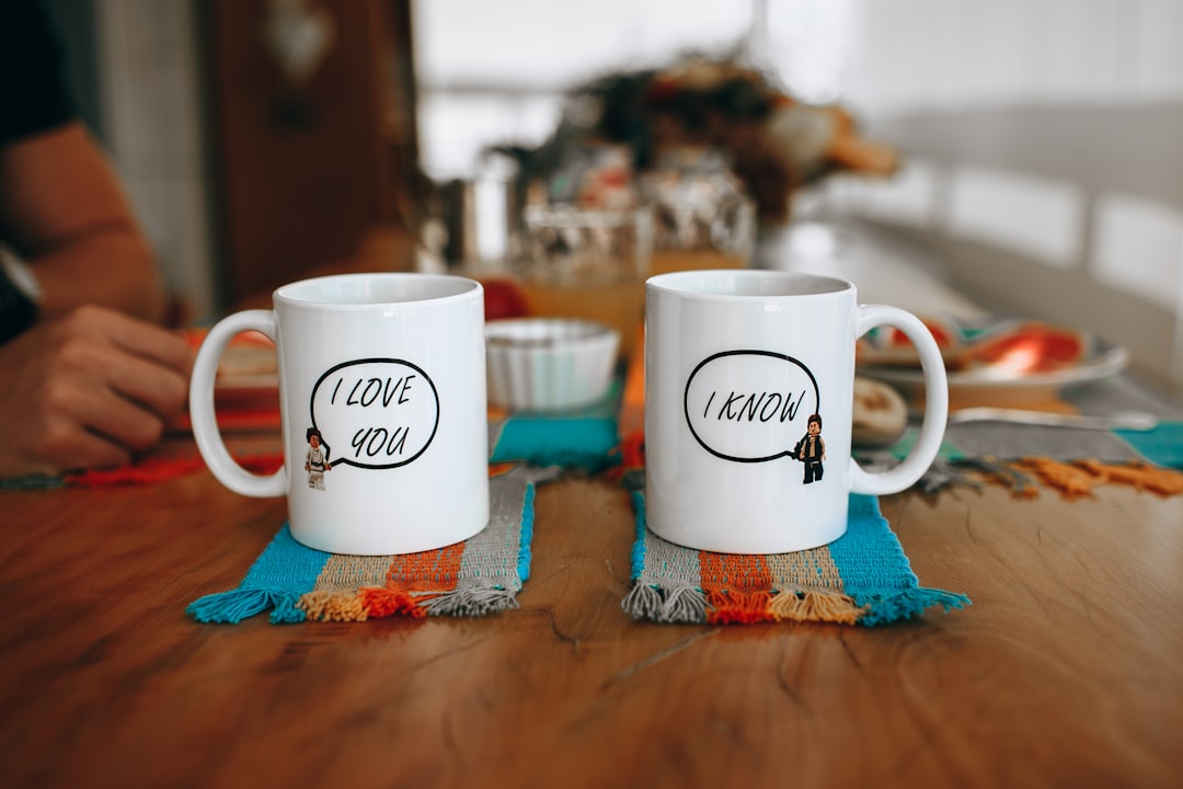 white-and-brown-ceramic-mug-on-blue-and-white-textile-ecaur5vkm74